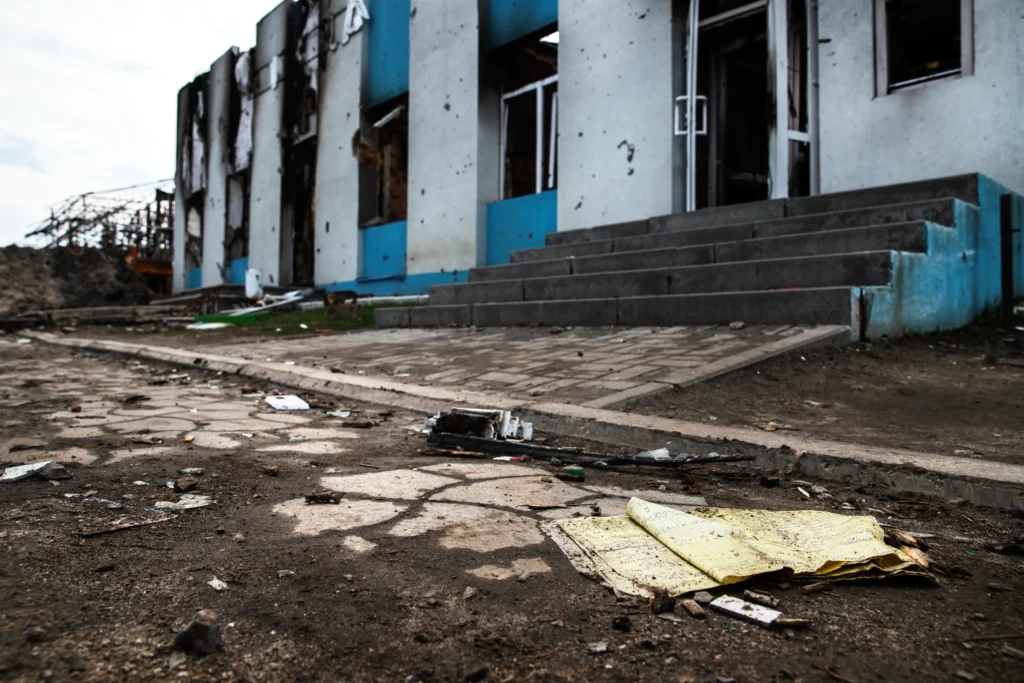 A yellow newspaper on the ground in front of a building.