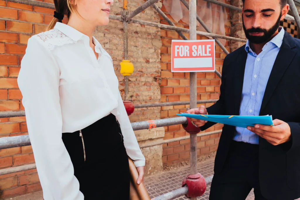 A man in a suit is showing a woman a piece of paper.